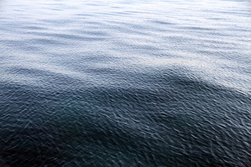 Weisser Schaum auf der Wasseroberfläche im Meer. Gischt am Ozean bei einer Fahrt mit dem Schiff. Wasser in Bewegung. Kleine Wellen