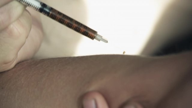 injecting needle into arm (staged)