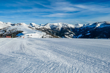 Fototapeta na wymiar View on the austrian alps in Bad Kleinkirchheim, Austria. Big ski resort. The slopes are perfectly gravelled. Lots of snow capped mountains. Winter sports in Alpine winter wonderland