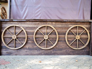 Three wooden round steering wheels on a wooden wall