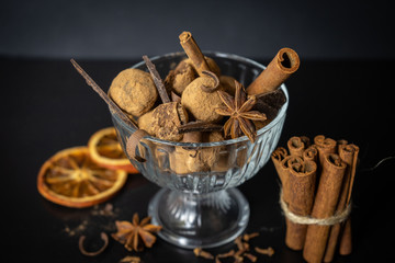 Handmade chocolate truffles in a glass candy bowl on a white marble stone on a dark background