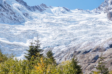 Fototapeta premium Dombay mountains, trekking in national park to the Alibek waterfall and glacier, autumn landscape