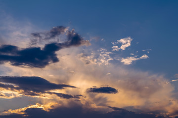 The sky at sunset. Cumulus clouds lit by the rays of the setting sun.