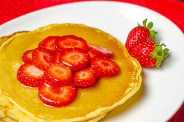 Detail of pancake with strawberries and syrup