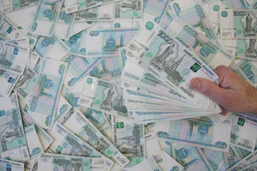 cash one thousandths of a banknote of Russian rubles in hand against the background of cash one thousandths of a banknote. Top view, flat lay. Business and finance concept