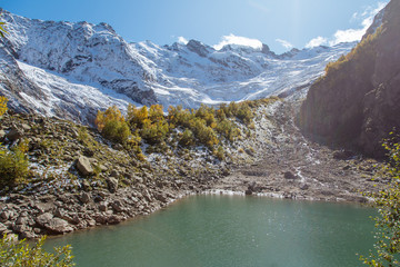 Beautiful turquoise lake in Dombay mountains, trekking in national park to the Alibek waterfall and glacier