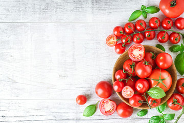 Fresh tomatoes and basil on white old table, top view. Beautiful red tomato vegetables with copy space. - obrazy, fototapety, plakaty