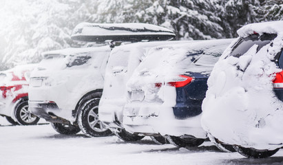 Cars covered with heavy white snow on calamity road. Winter car concept in storm.