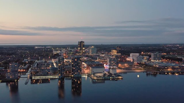 Aerial view of Almere city center with its modern architecture, illuminated at dusk. Suburban city near Amsterdam, The Netherlands.