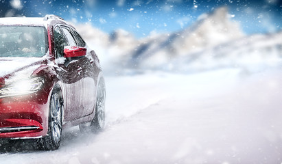 Car in winter on snowy road. Speed snow cars background with mountains. - Powered by Adobe