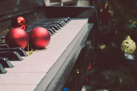 Red christmas tree decoration ball Put on the piano The background is decorated with Christmas decorations. Blurred Or New Year's event Feel the Christmas event and celebrate the festival.