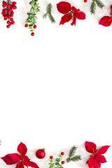Christmas decoration. Frame of flowers of red poinsettia, branch christmas tree, ball, red berry on a white background with space for text. Top view, flat lay