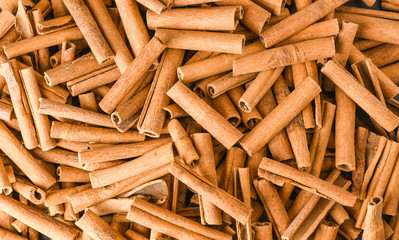 Cinnamon background. Pile of cinnamons stick top view.