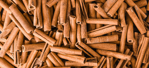 Cinnamon stick background wide baner or panorama top view.