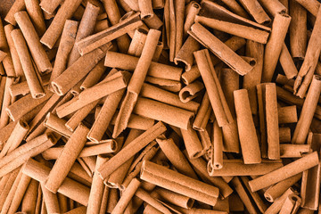 Cinnamon background. Pile of cinnamons stick top view.