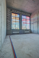 Unfinished construction empty room. Walls from lightweight aggregate concrete blocks with empty...