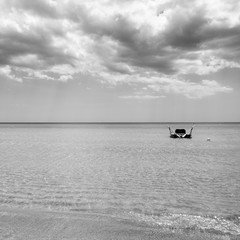 Fototapeta premium Rescue rowing boat on the sea against a cloudy and sunny sky. Beautiful view. Crystal clear water. Paradise beach.