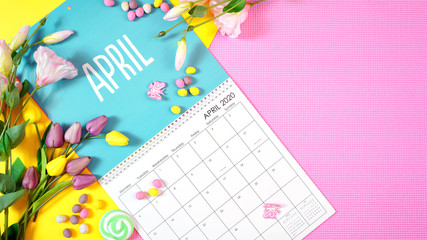 On-trend 2020 calendar page for the month of April modern flat lay with seasonal food, candy and colorful decorations in popular pastel colors. Copy space. One of a series for 12 months of the year. - obrazy, fototapety, plakaty