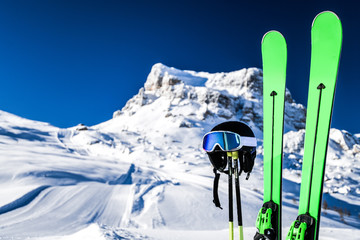 Skis in snow, mountains and ski concept equipments in sunny winter day. Fresh or new groomed slope at best piste resort. - obrazy, fototapety, plakaty