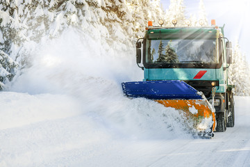 Sow plough truck removing fresh heavy snow from road in winter season. Maintenance cleaning vehicle.