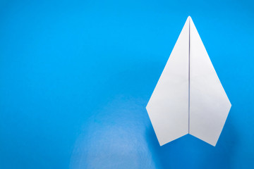 paper airplane made of white paper on a light blue background, copy space, mock up