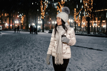 Girl in warm clothing on street in evening.
