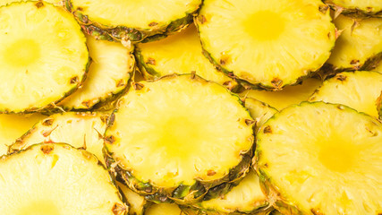 Pineapple juicy yellow slices background. Top view.