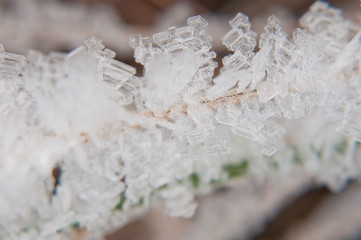 Cold morning outdoors in winter with frozen ice cubes of snow on dry yellow grass