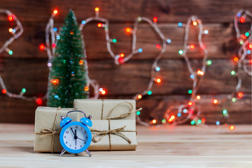concept, New Year is coming, the alarm clock on the table among the Christmas tree and decorations