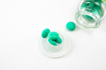 glass bottle for tablets isolated on a white background, tablets which have fallen out of the yellow container
