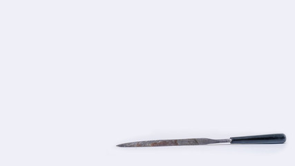 Long rusty old file with plastic handle isolated on white background.