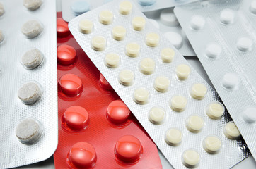 blisters with round multi-colored tablets red yellow blue white  light background close-up macro, antibiotics, vitamins, analgesic antipyretic, antihistamines, antiallergic