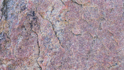 Texture of granite. Granite rock with reddish color. Background from solid stone. Pattern with natural material. Widescreen