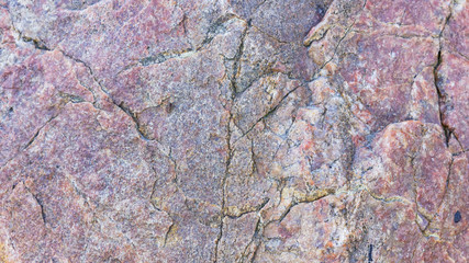 Texture of granite. Granite rock with reddish color. Background from solid stone. Pattern with natural material. Widescreen