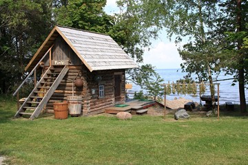 Small wooden bathhouse on the shore of the bay in Kepming. Latvia, June 2019