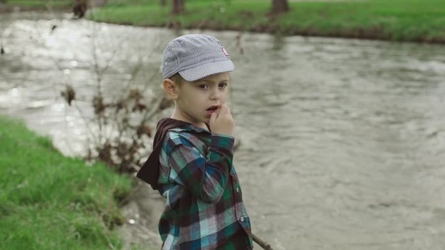 Little boy looks at the lake in the park
