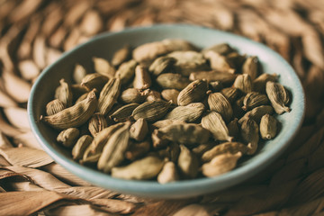 Heap of cardamom seeds in a bowl. Close up view of cardamom seeds as background for design. Organic and healthy food.