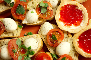 tartlets with red salmon caviar, slices of fresh salmon, cheese, avocado and tomatoes