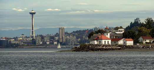 Fototapeta na wymiar The view of Alki Point Lighthouse and Seattle skyline including Space Needle from Puget Sound Waters 