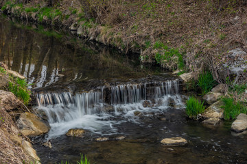 Brumovka river with small weir near Valasske Klobouky town in spring morning