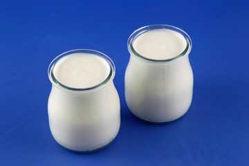 Tubs of natural yogurt, derived from cow's milk.