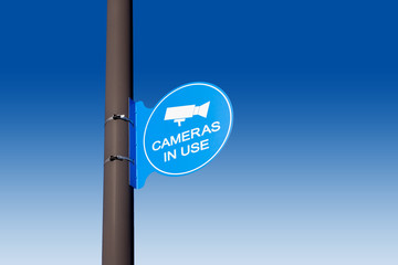 Cameras in Use blue sign on a pole
