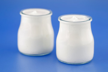 Tubs of natural yogurt, derived from cow's milk.