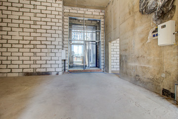 Unfinished construction empty room. Walls from lightweight aggregate concrete blocks with empty...