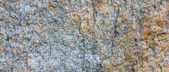 Granite texture. Granite rocks with porous surface. Background from solid stone. Pattern with natural material. Widescreen