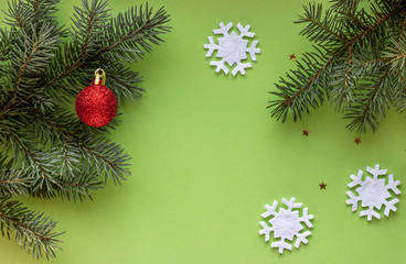 Christmas flat lay with green Christmas tree branches, snowflake and red ball. New Year. Top view