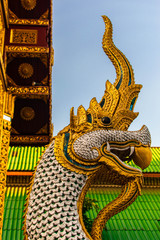 Fototapeta na wymiar A golden dragon on the roof of Thai temple