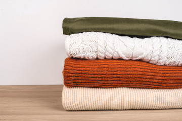 Pile of warm clothes on the table. Spring-Summer 2020 Colors.