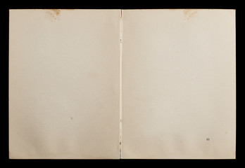 Antique book unfolded showing textured pages isolated on black background.