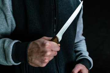 A man holds a kitchen knife in his hand